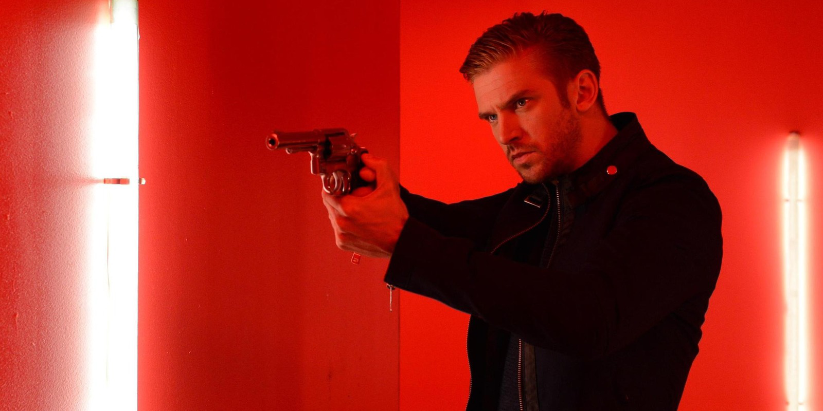 Dan Stevens pointing gun as David in The Guest