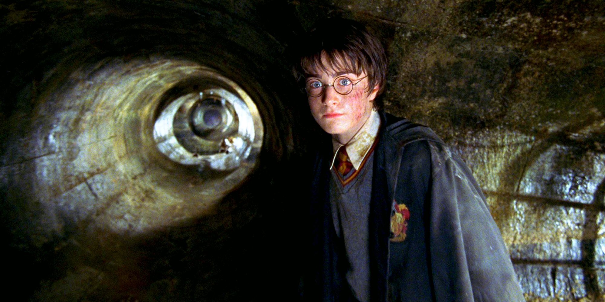 Harry em pé nos canos dentro da Câmara Secreta em Harry Potter