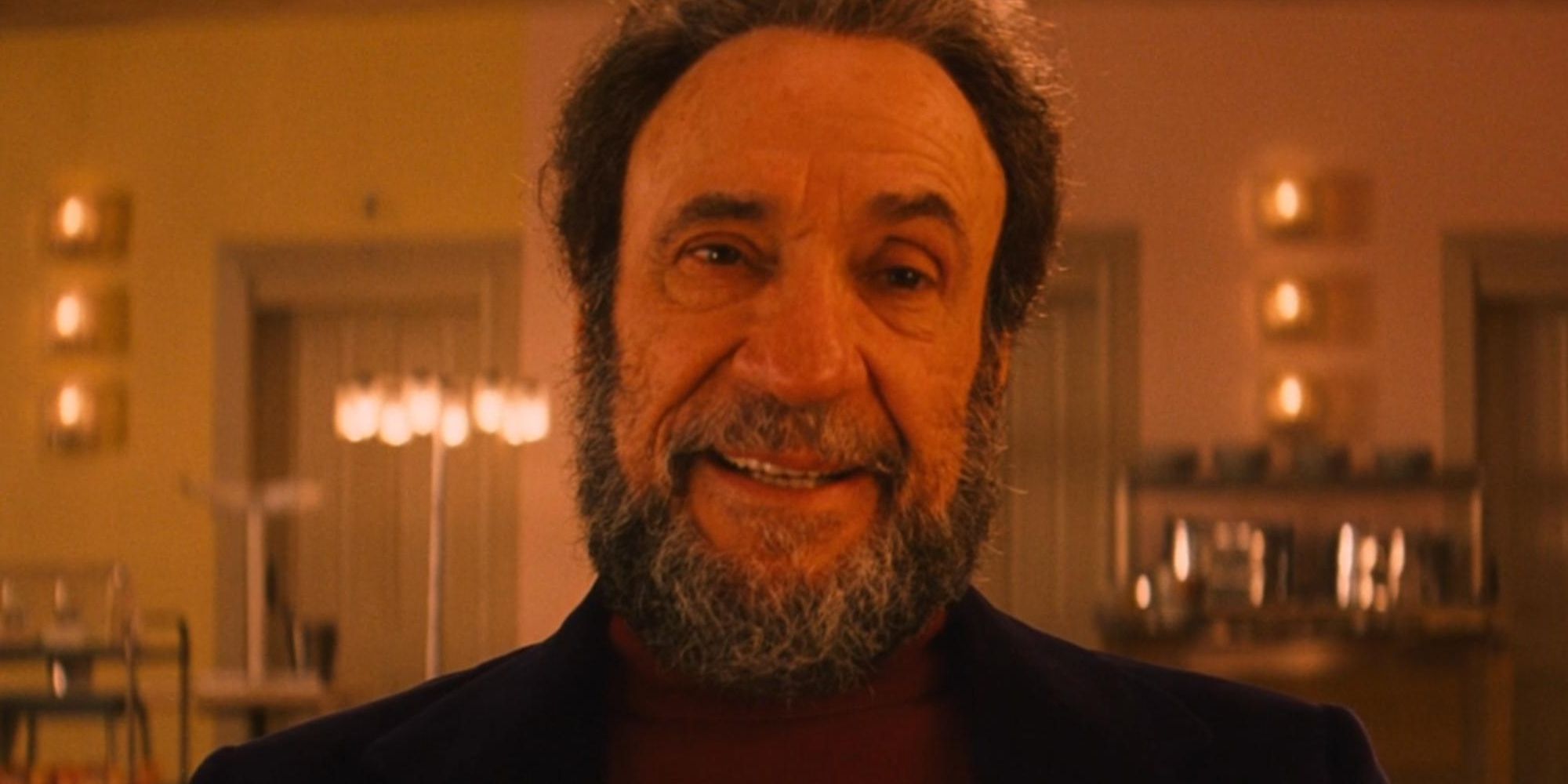 F Murray Abraham as Mr Moustafa sitting at a table in the Grand Budapest Hotel