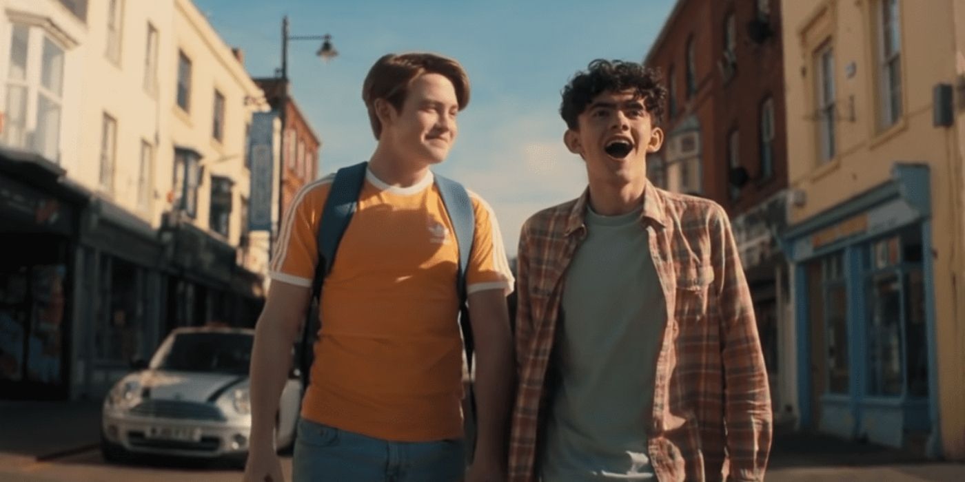 Nick and Charlie standing in the street smiling in Heartstopper.
