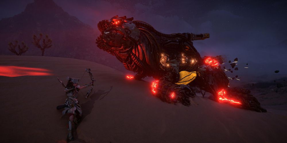 Aloy targets a monster in the sand at night in Horizon Forbidden West