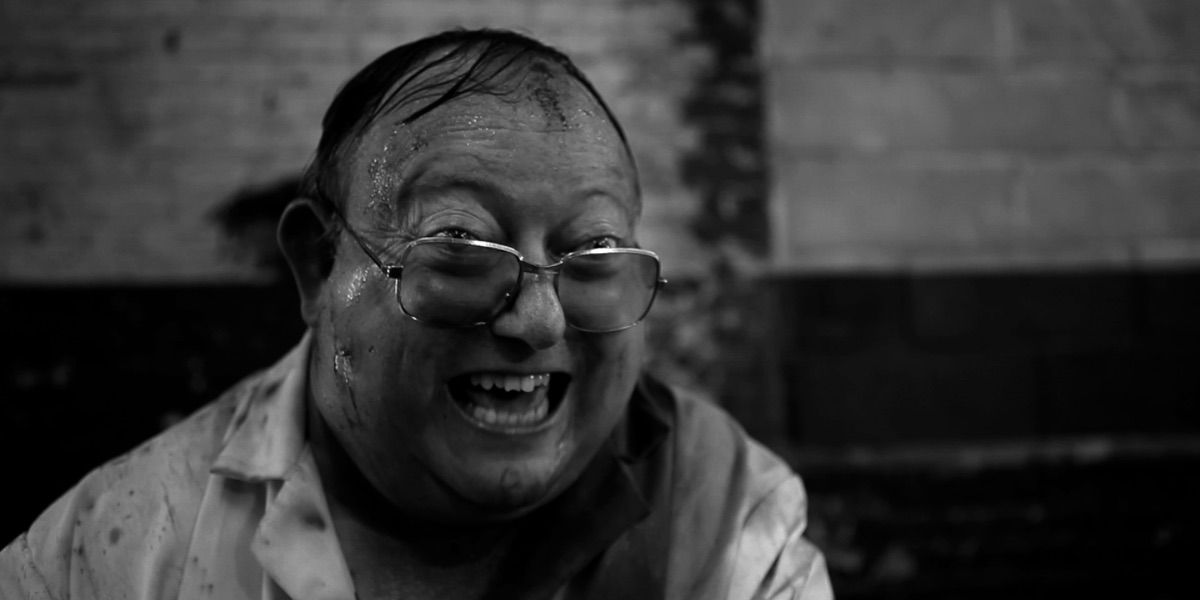 A man laughs while covered in blood from The Human Centipede 2