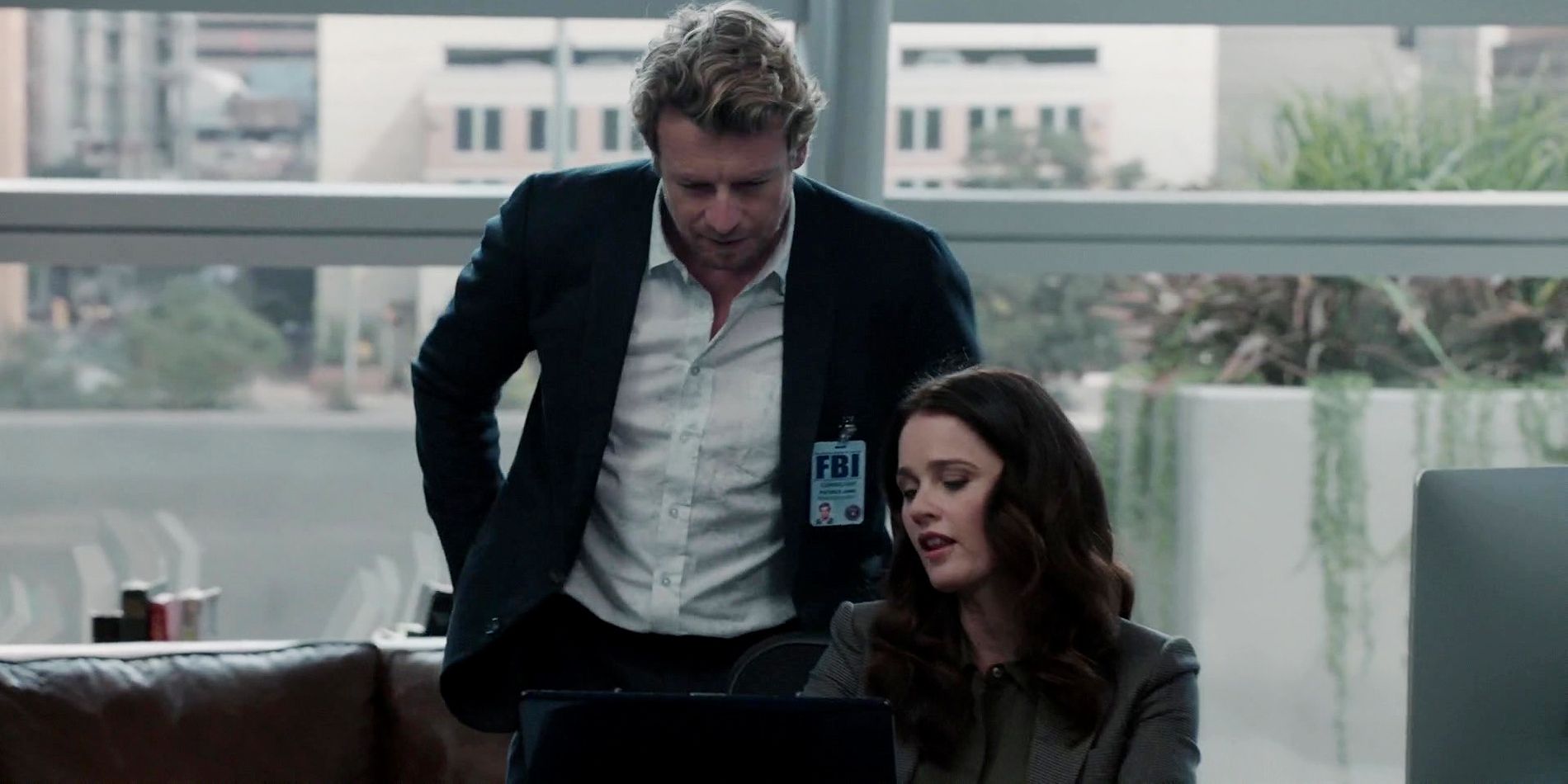 Jane and Lisbon in The Mentalist. Theresa is looking at a computer and Patrick is standing behind her.