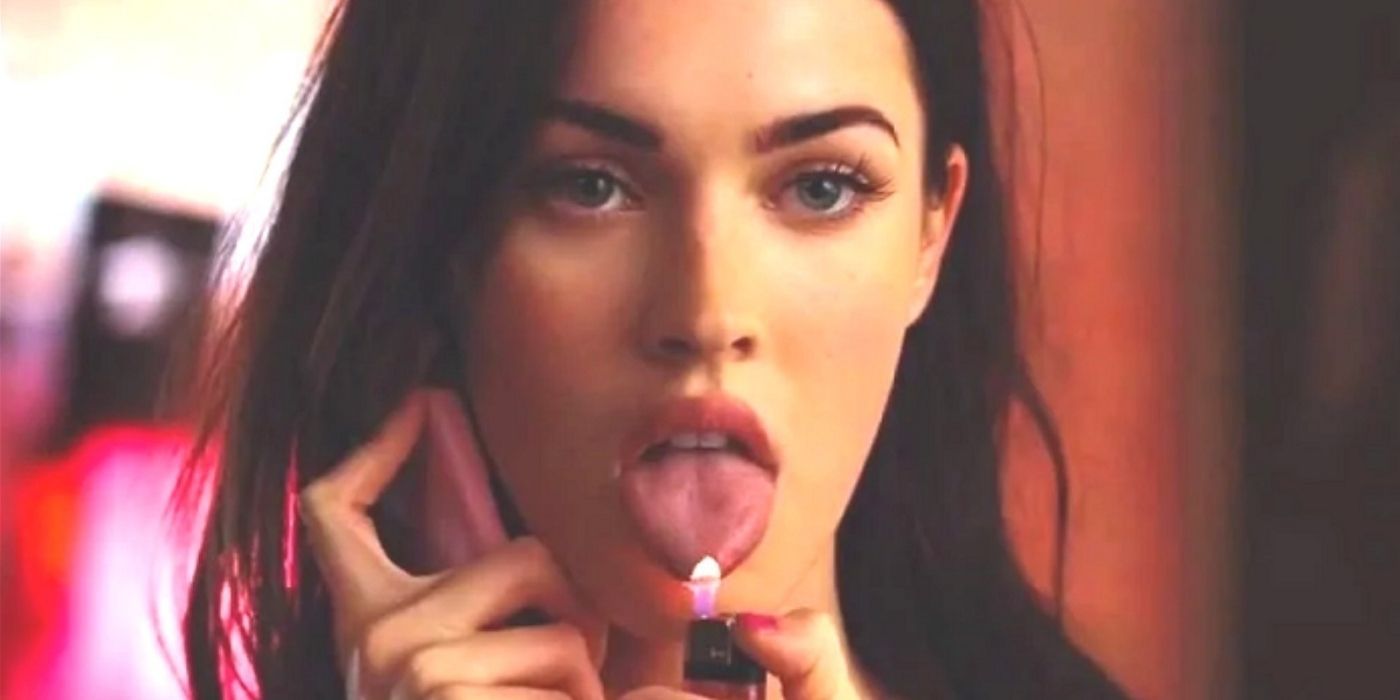 Megan Fox talking on the phone holding the flame of a lighter to her tongue