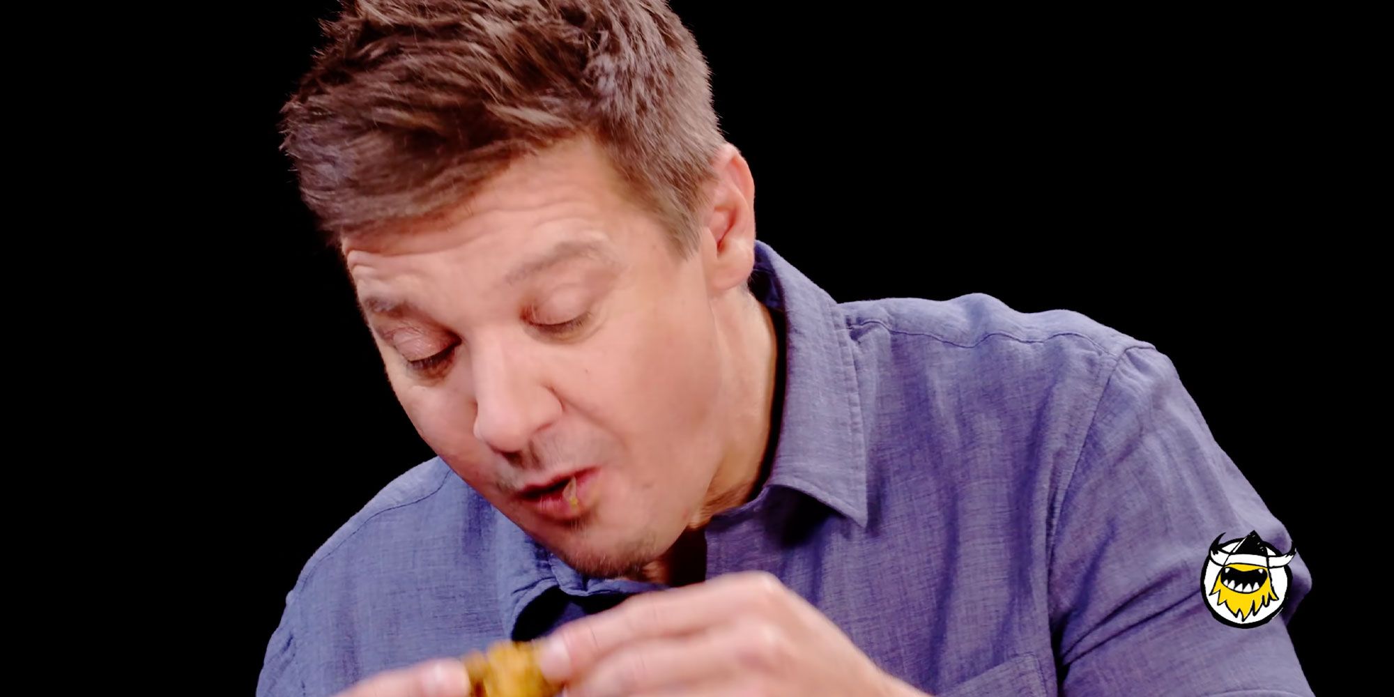 Jeremy Renner eating chicken on Hot Ones