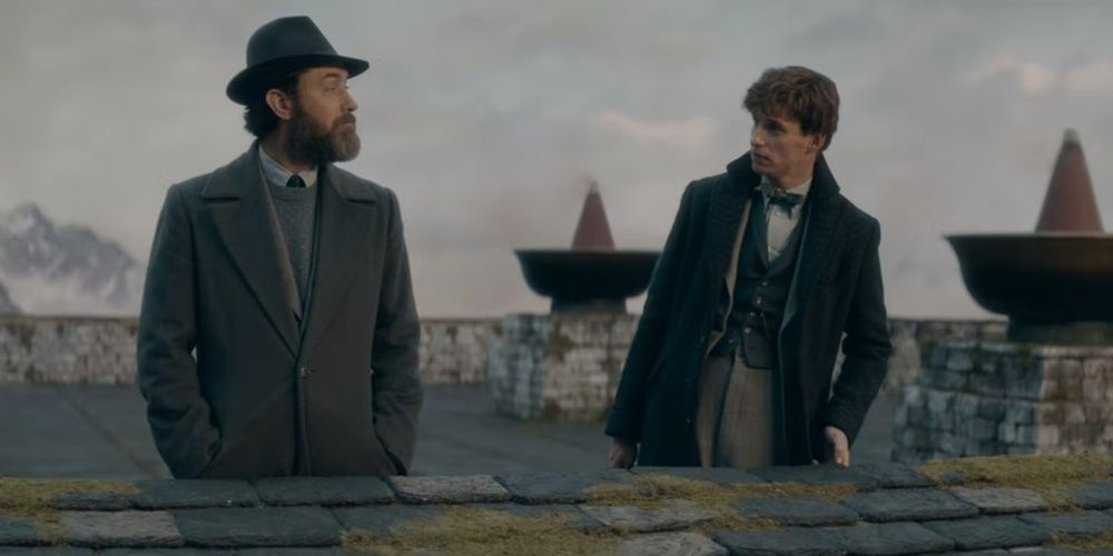 Newt Scamander talking to Albus Dumbledore by a cliff in Fantastc Beasts 3 Cropped 1