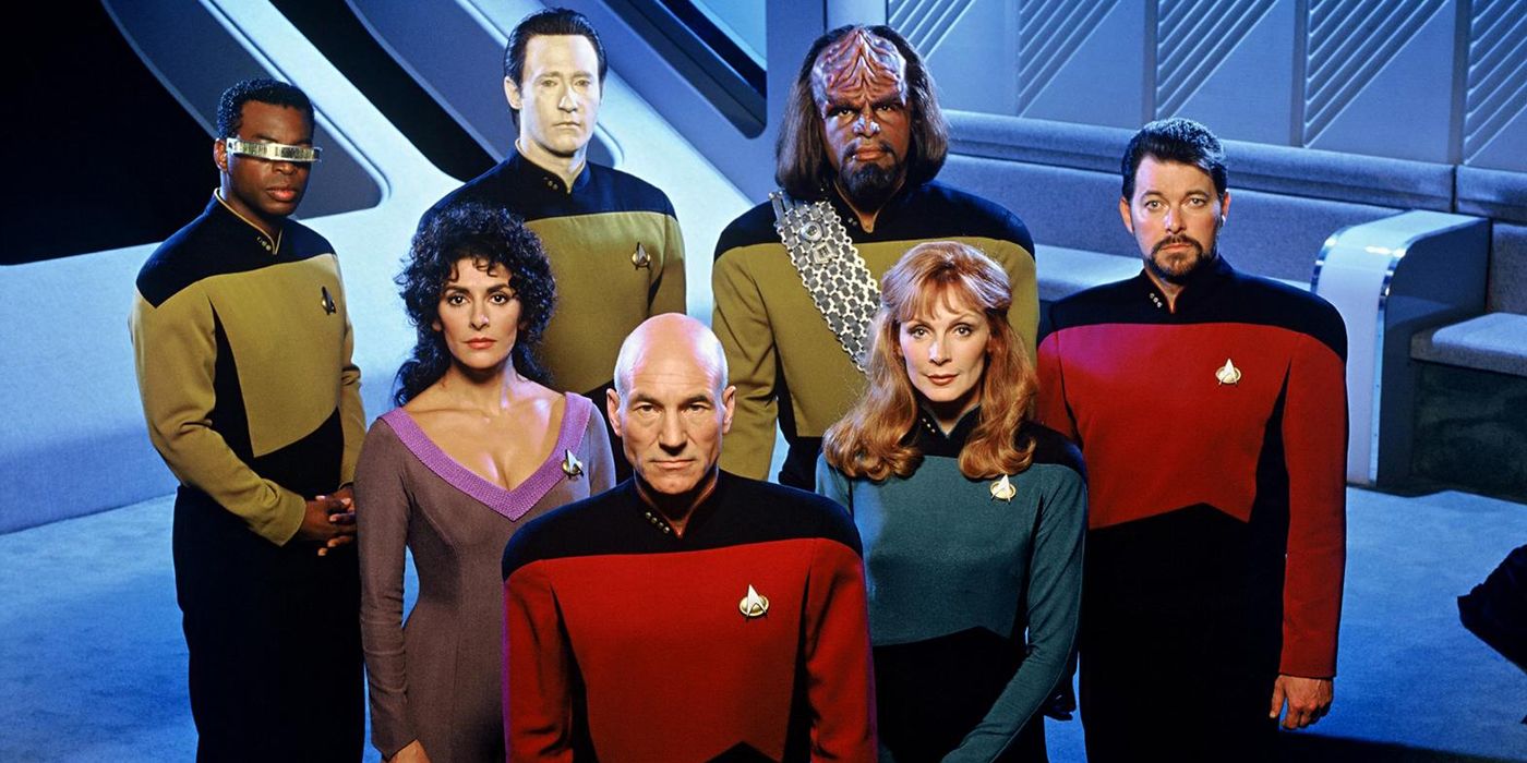 The crew of the Enterprise pose together while looking up from The Next Generation 