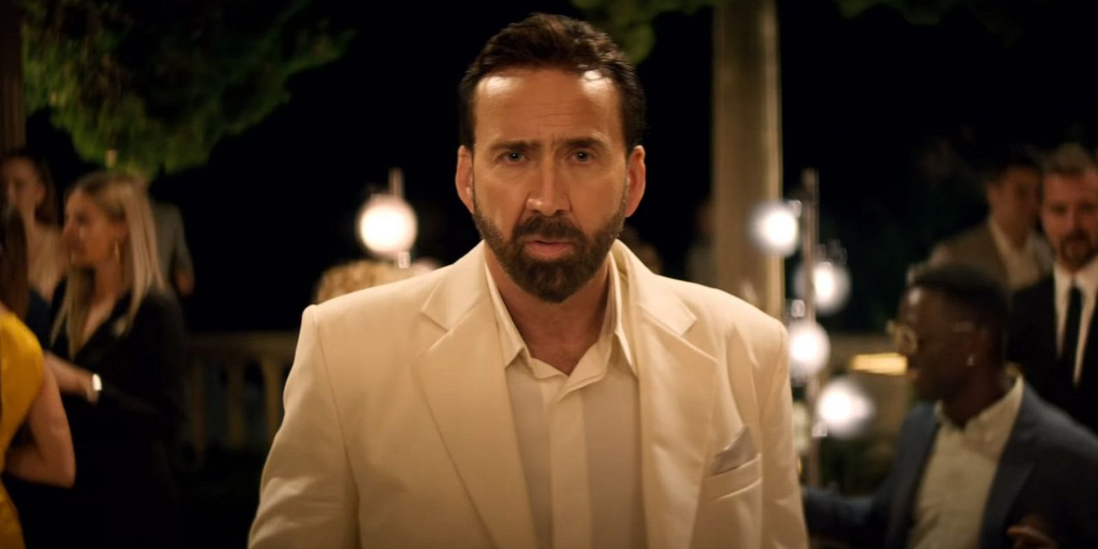 Nic Cage in TUWOMT wearing white tuxedo at a party