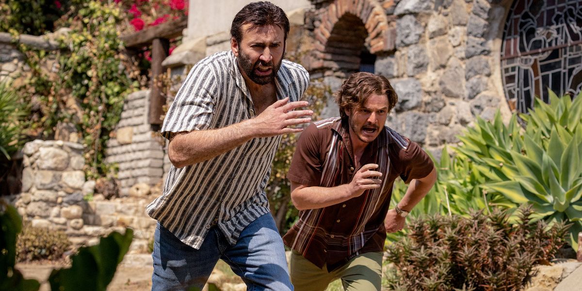 Nick Cage (Nicolas Cage) and Javi (Pedro Pascal) running in The Unbearable Weight of Massive Talent