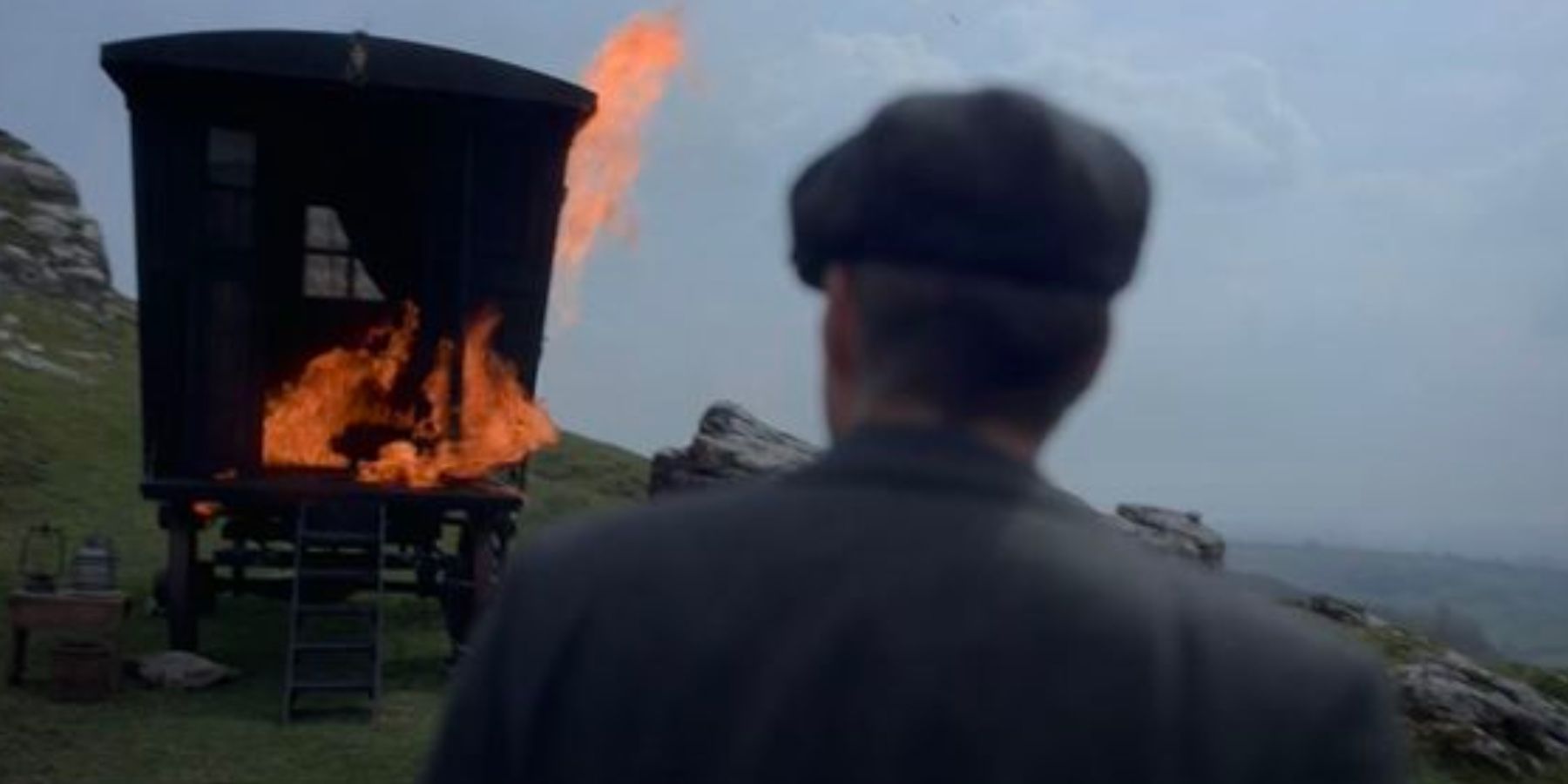 Cillian Murphy como Tommy Shelby observa cómo arde su carro en la temporada 6 de Peaky Blinders.