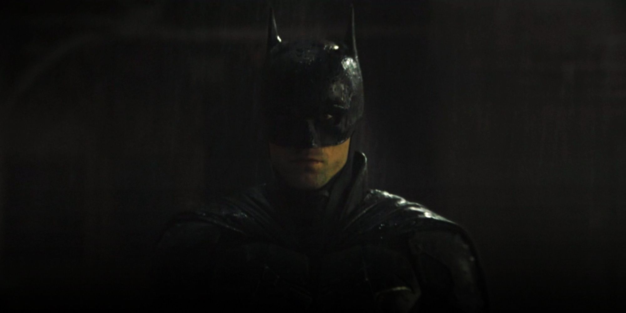 Robert Pattinson as Batman marching through the rain in The Batman 2022