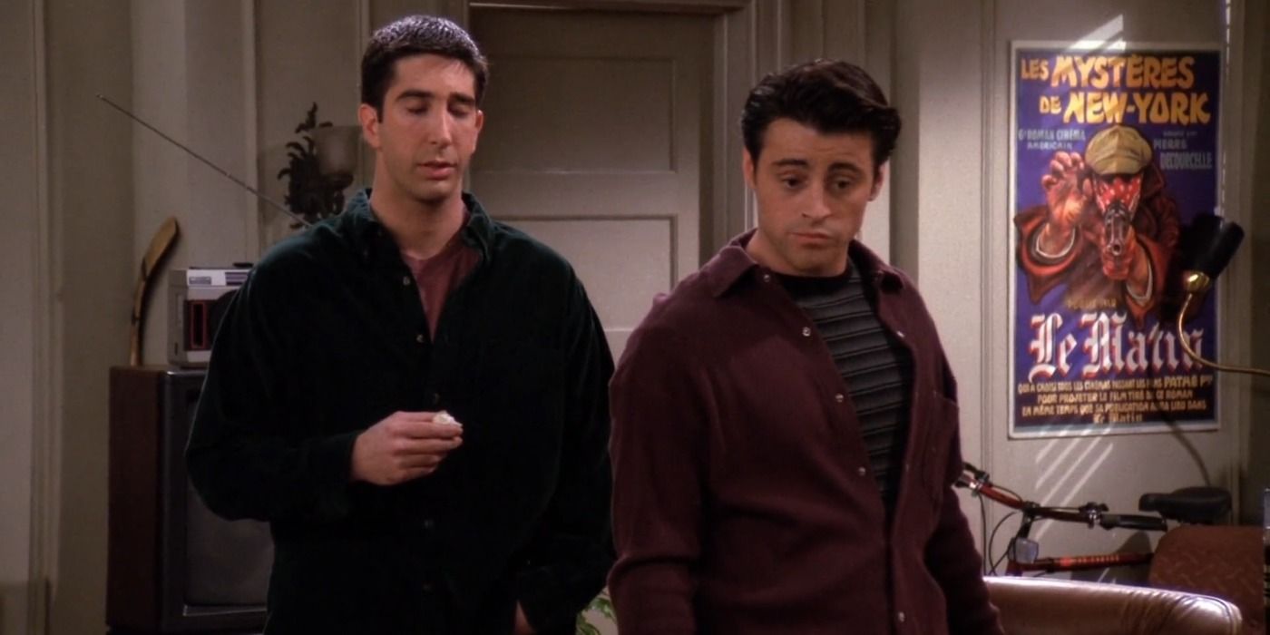 Ross stands behind Joey in the living room in Friends