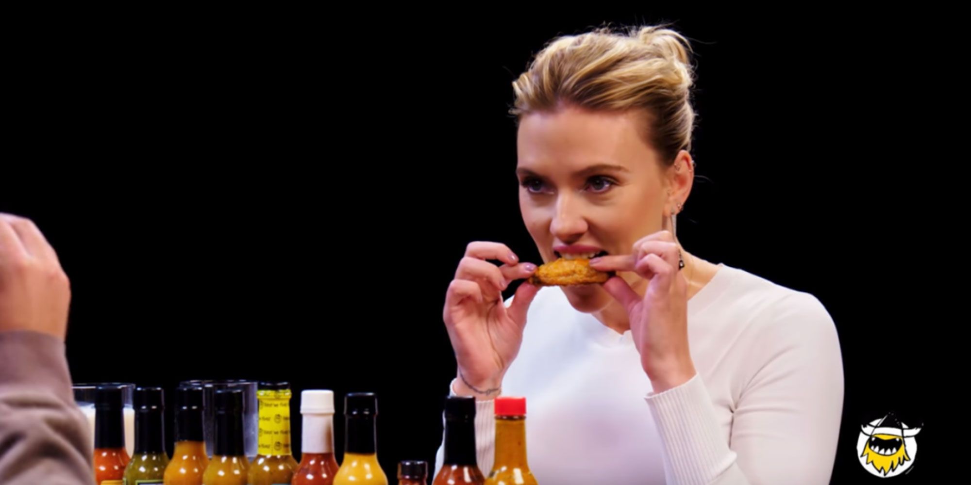 Scarlett Johansson eating a chicken wing on Hot Ones