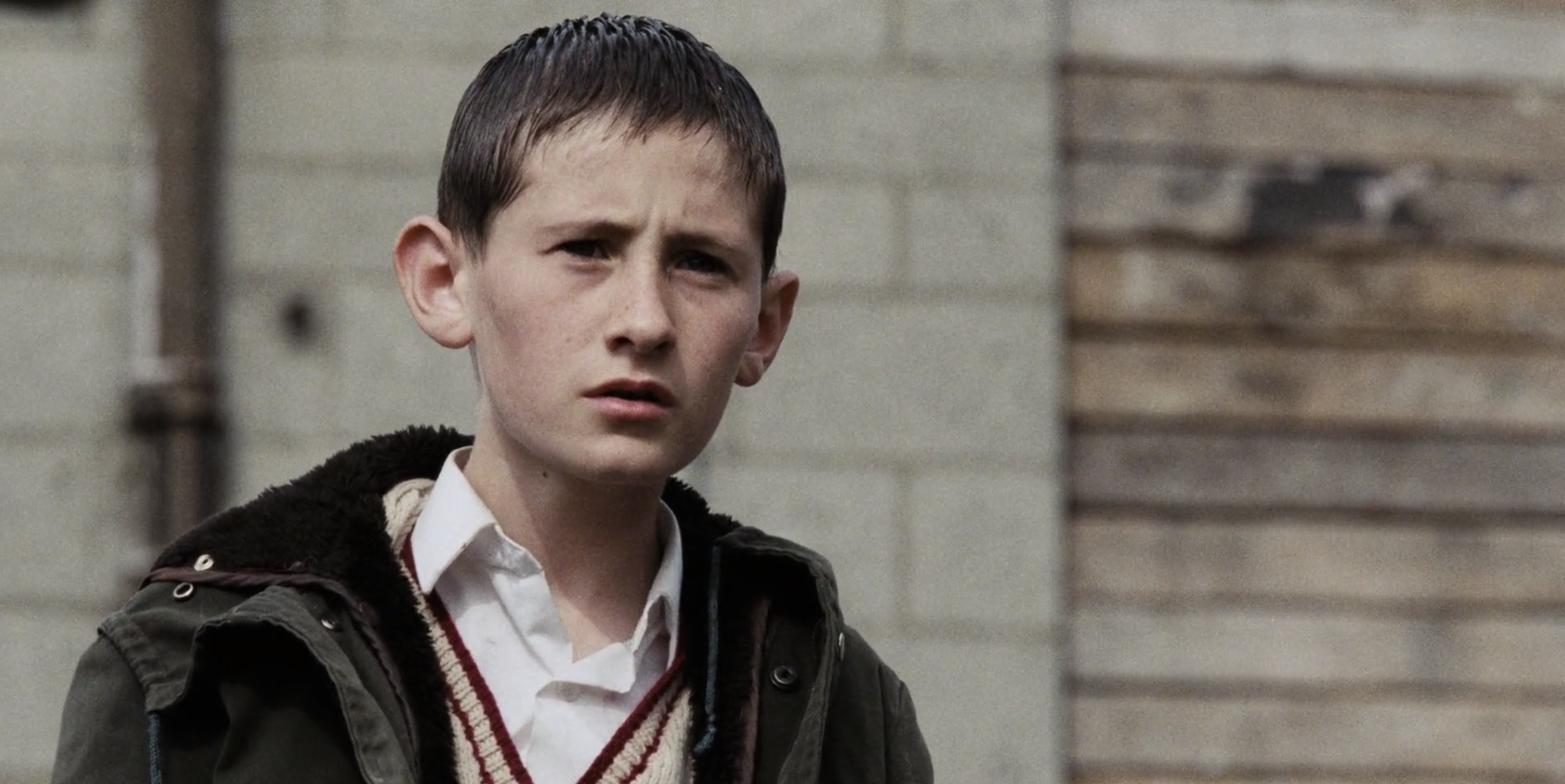 Boy from Lynne Ramsey's acclaimed film Ratcatcher squinting at something.