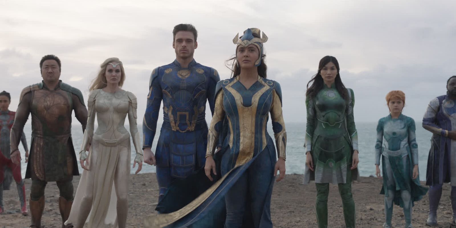The cast of Eternals standing in front of an ocean