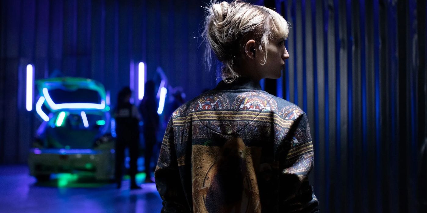 Adrien/Alexis standing wearing a jacket in Titane