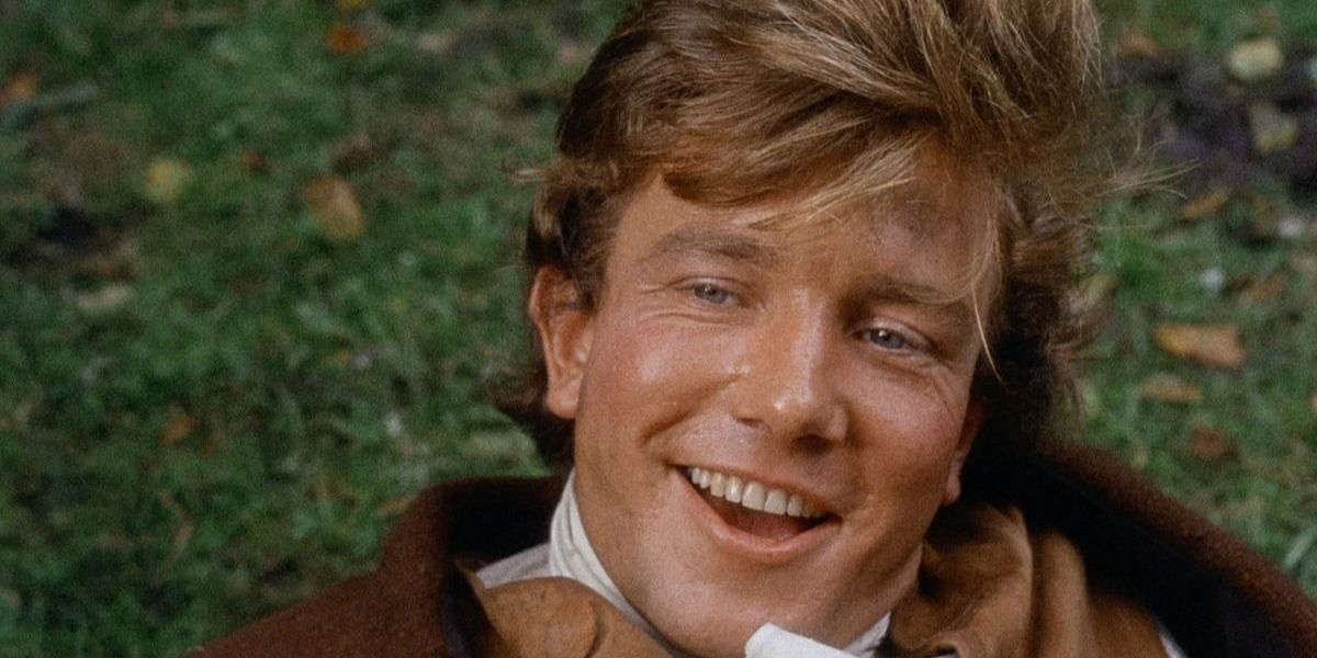 Tom jones movie main character on grass smiling up