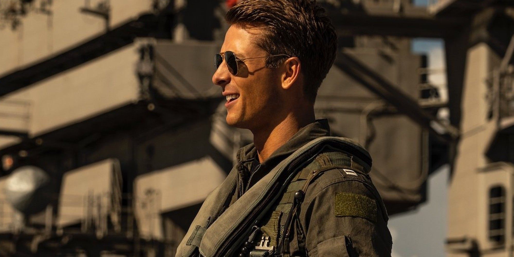 An image of Glen Powell as Hangman standing by a helicopter in Top Gun 2.