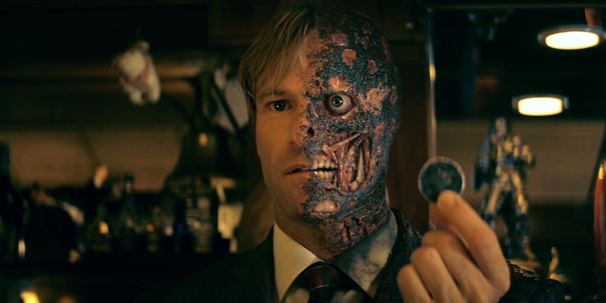 Two-Face holding his coin at the bar in The Dark Knight