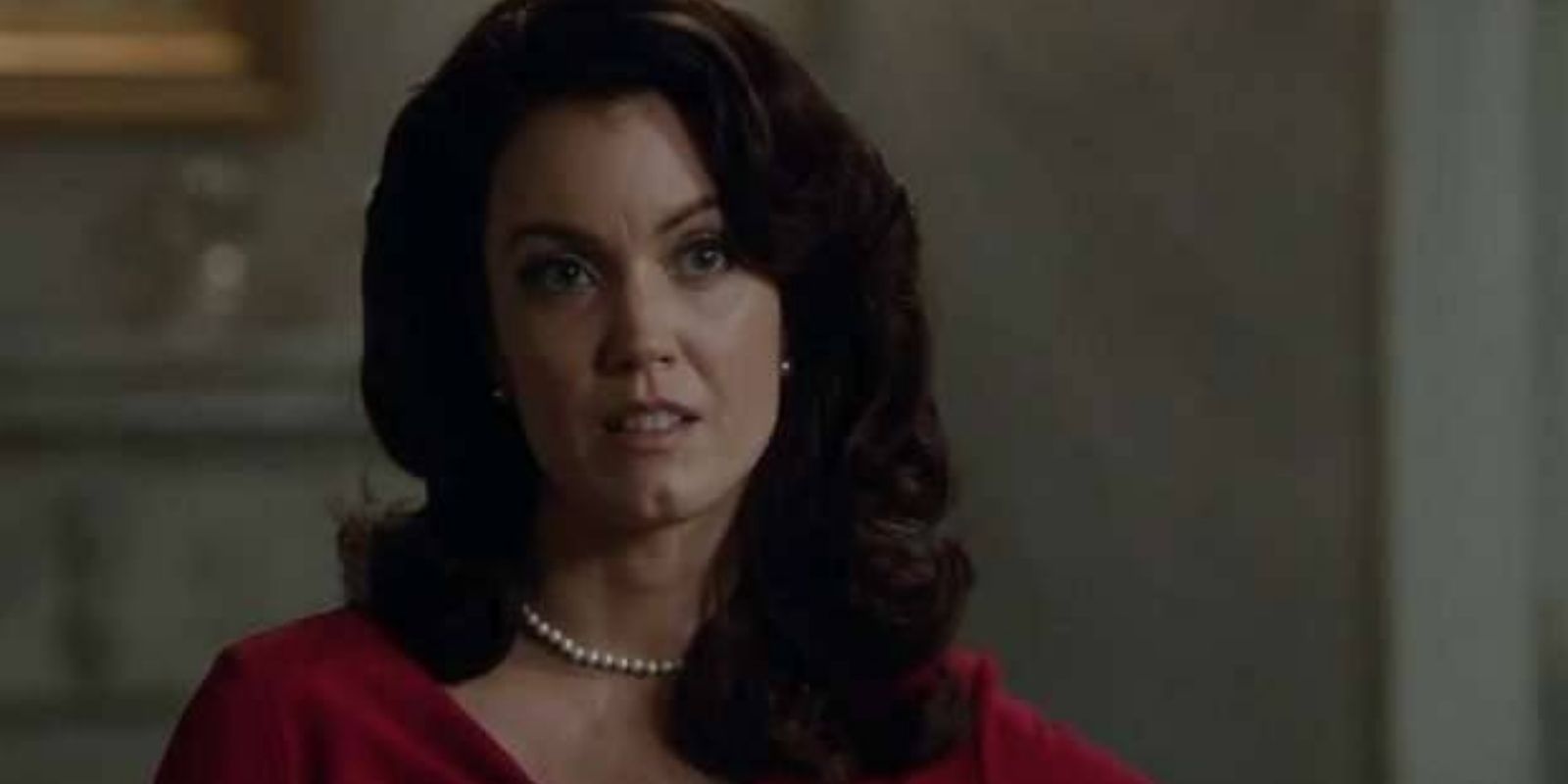 Mellie looks to someone off screen wearing red
