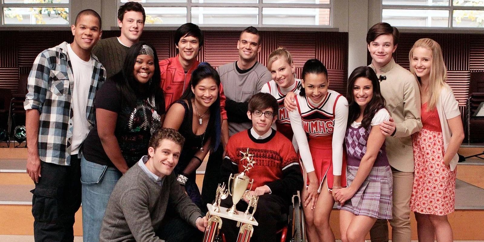 The Glee Club posing with their Sectionals trophy on Glee.