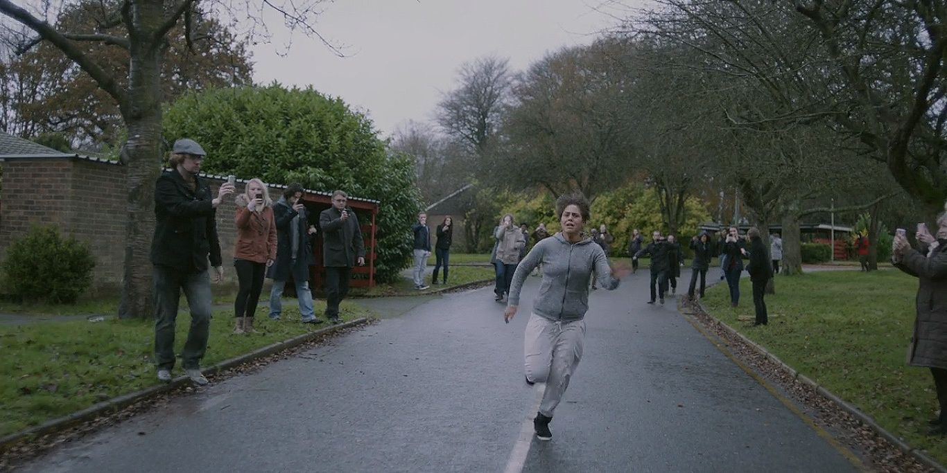 Victoria running down a road with people filming her in &quot;White Bear&quot;