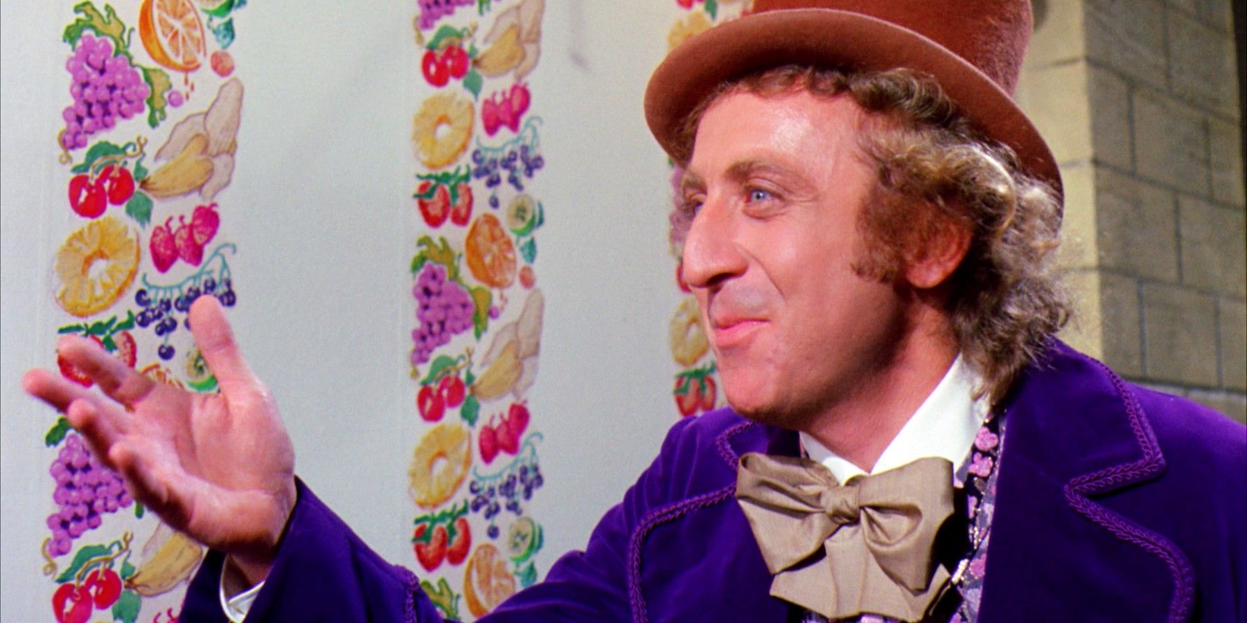 Gene Wilder in Willy Wonka and the Chocolate Factory smiling and wearing a purple suit and top hat