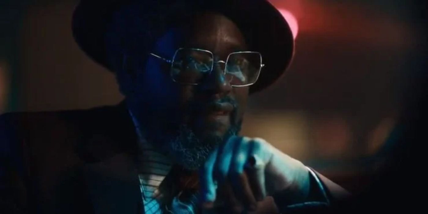 Lil Rel Howery wearing glasses and a hat in a dark bar in Judas and the Black Messiah.