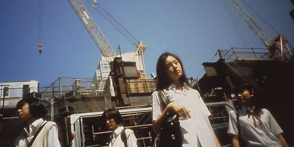 Characters in the Japanese film Love Pop in front of a construction site.