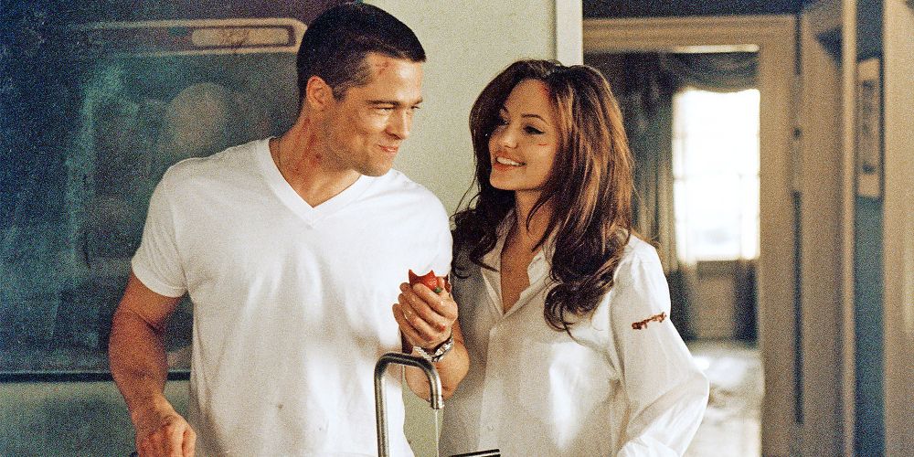 John and Jane hold hands by a sink in Mr. &amp; Mrs. Smith