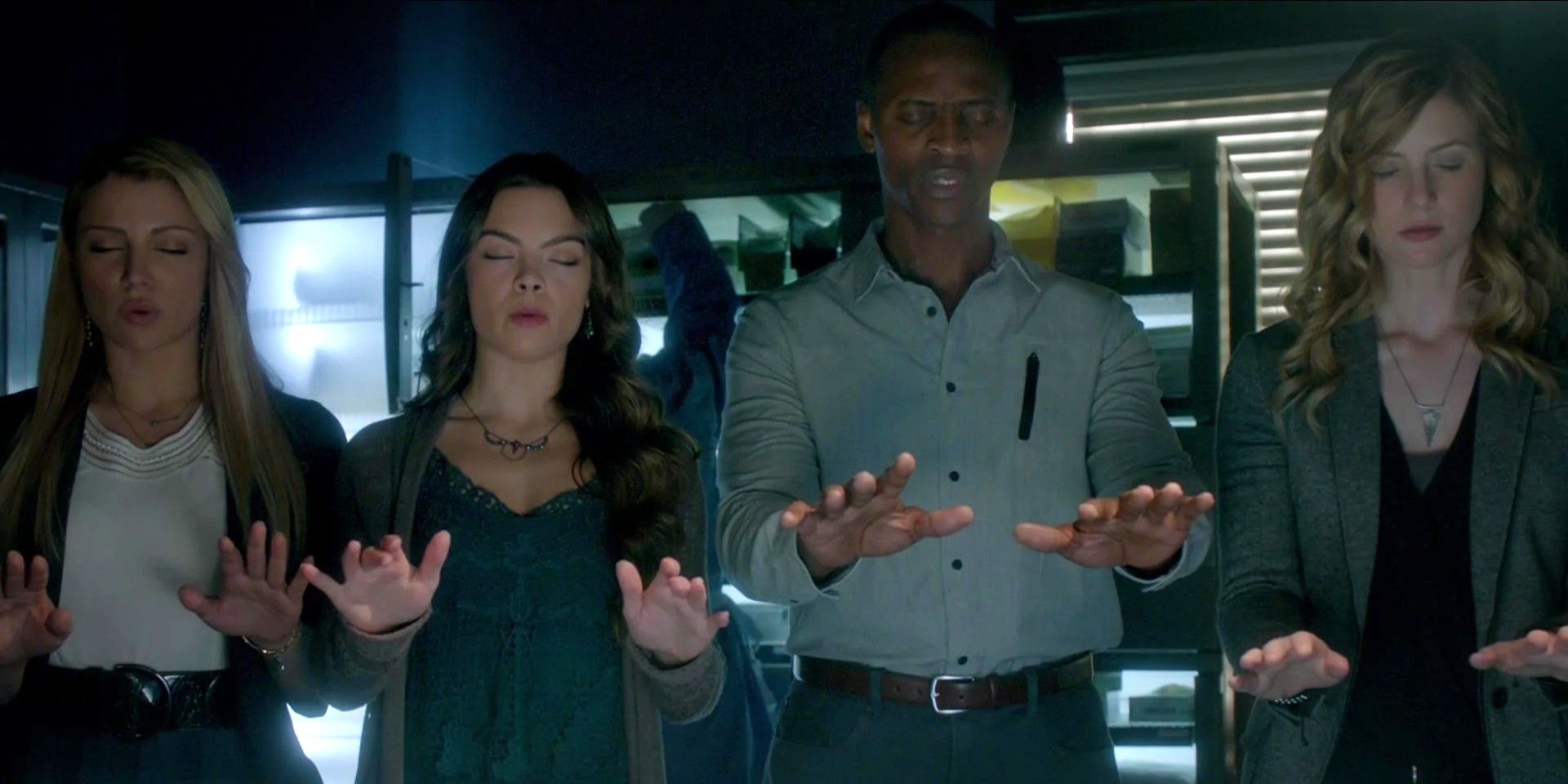 The heretics performing a spell with their hands raised in The Vampire Diaries