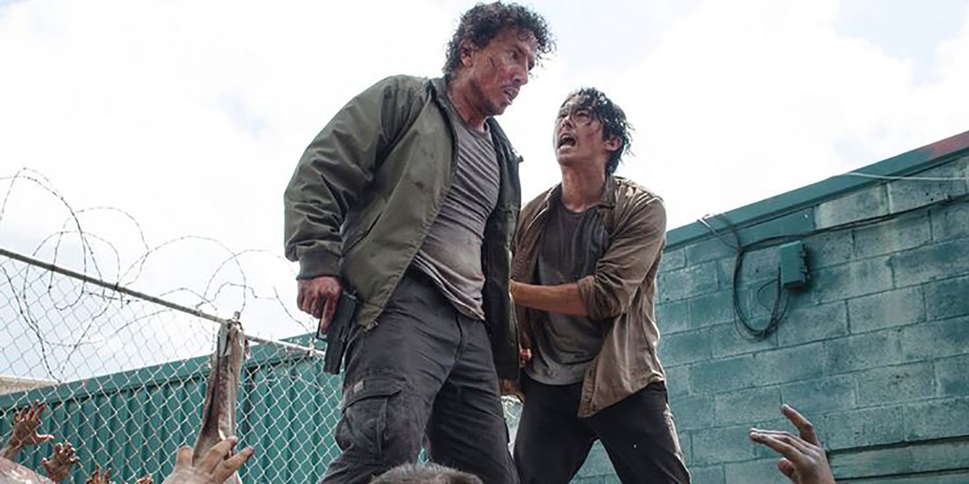 Glenn pleading with Nicholas on The Walking Dead as they are surrounded by walkers and standing on top of a dumpster.