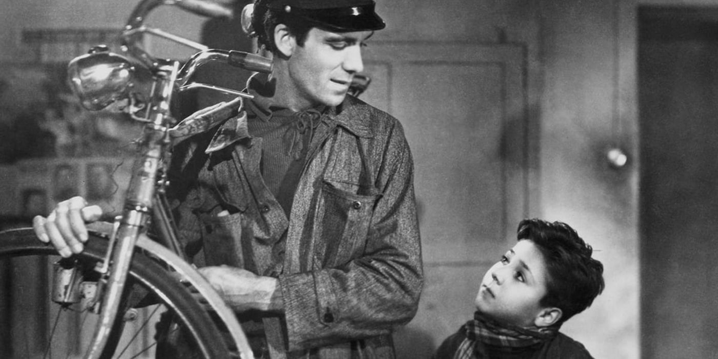 A man carrying a bike and looking at a boy in Bicycle Thieves.