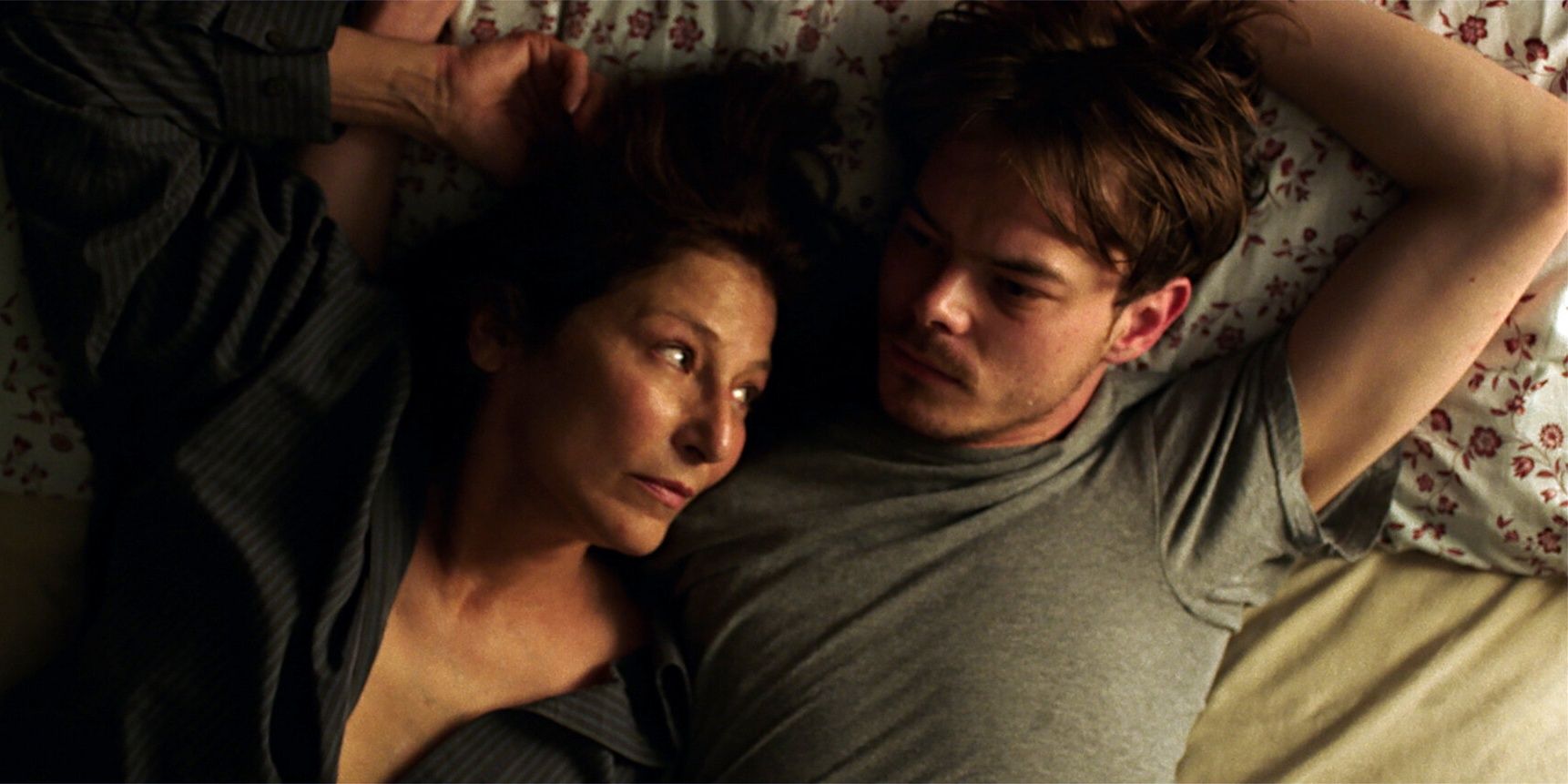 Charlie Heaton lying in bed with Catherine Keener in No Future 