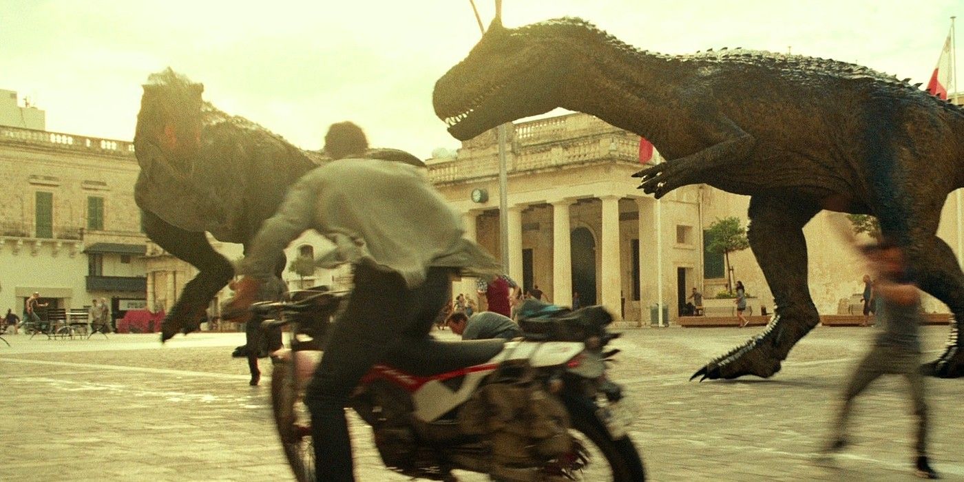 Chris Pratt as Owen on motorcycle in front of large dinosaurs in Jurassic World Dominion