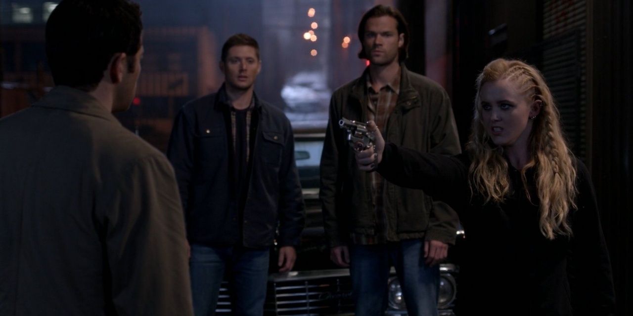 Claire points a gun at Castiel while Sam and Dean watch in Supernatural 