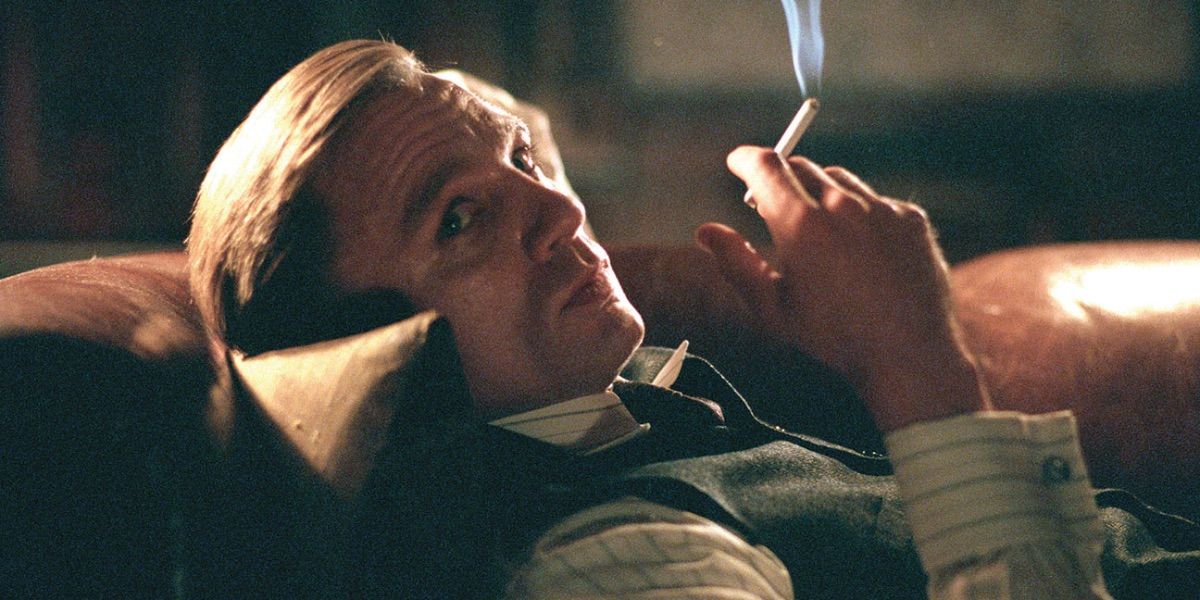 Daniel Craig smokes a cigarette while looking on from Road to Perdition