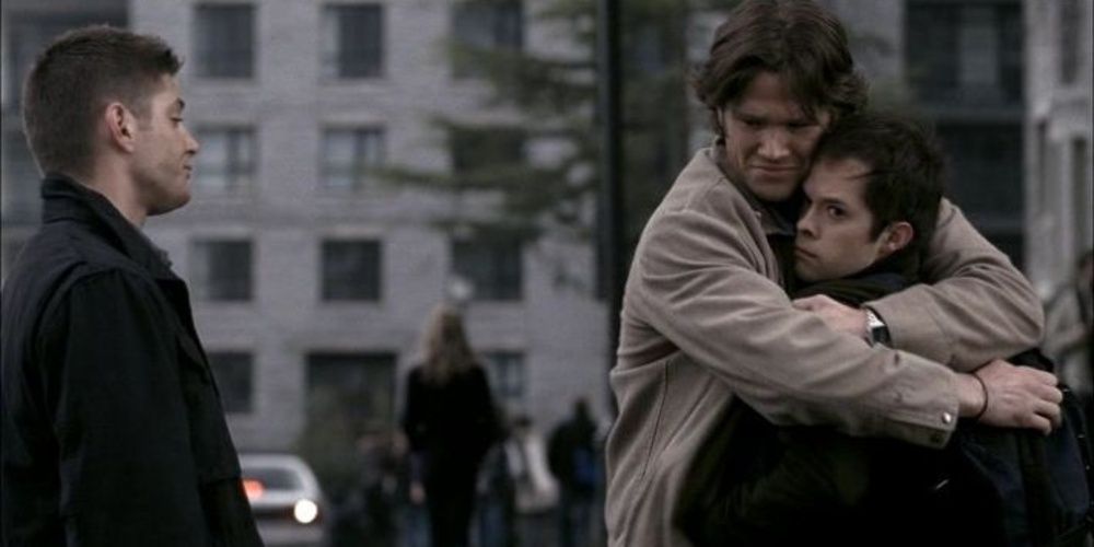 Dean watches Sam hugging a man in Supernatural Cropped 1