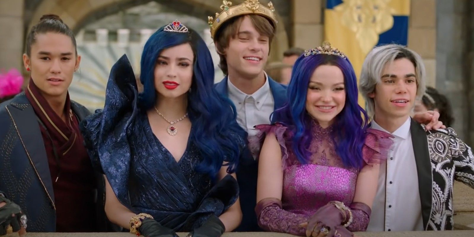 The main cast of Descendants leaning over a wall and smiling.