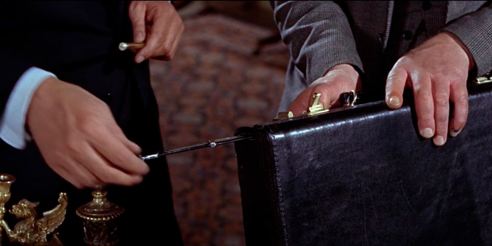 Desmond Llewelyn as Q shows Sean Connery as James Bond the attache Attaché case from from russia with love and 007 pulls the hidden knife from it