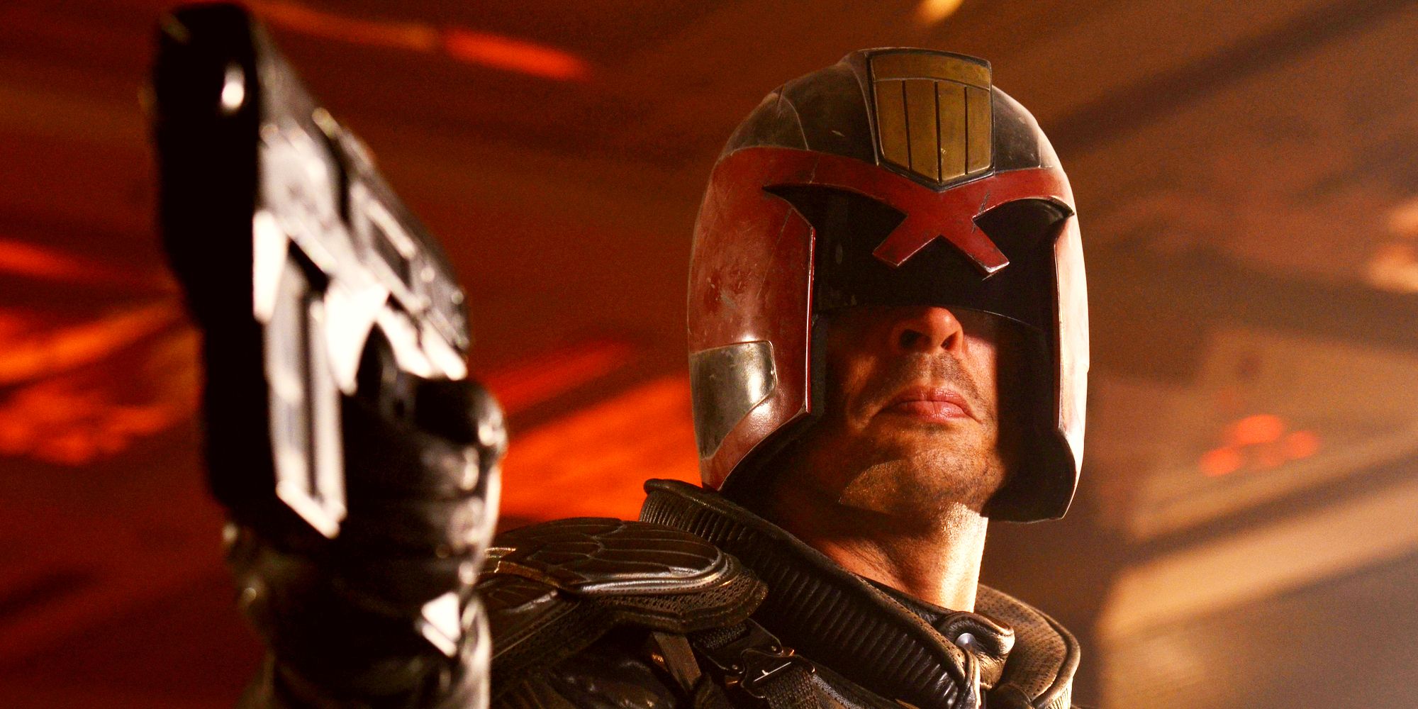 Karl Urban as Judge Dredd aiming his gun in Dredd