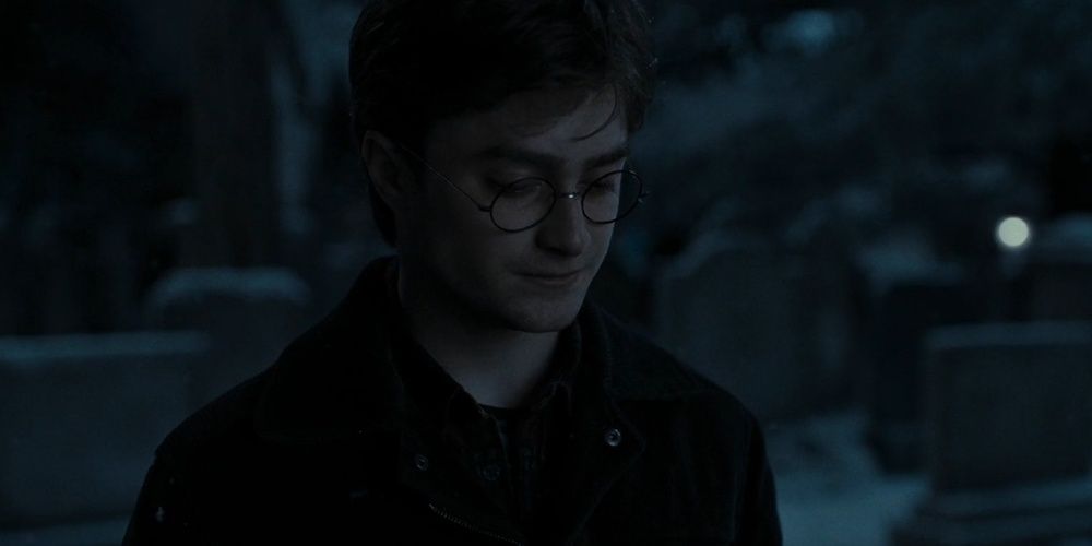 Harry Potter looking down sad in a graveyard in Deathly Hallows Part 1 