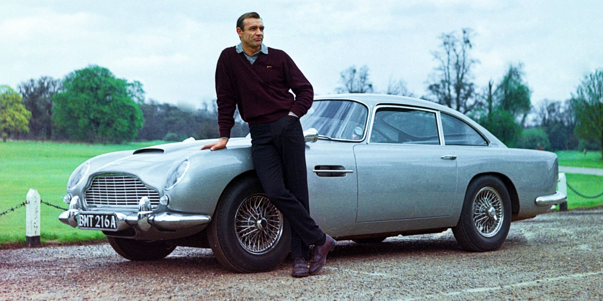 James Bond Actor Sean Connery standing in front of an Aston Martin