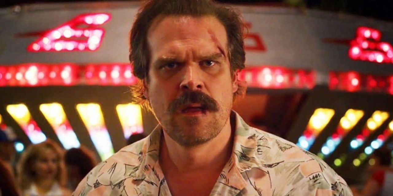 Jim Hopper at the Starcourt Mall with a confused expression and a bloody cut near his eye. 