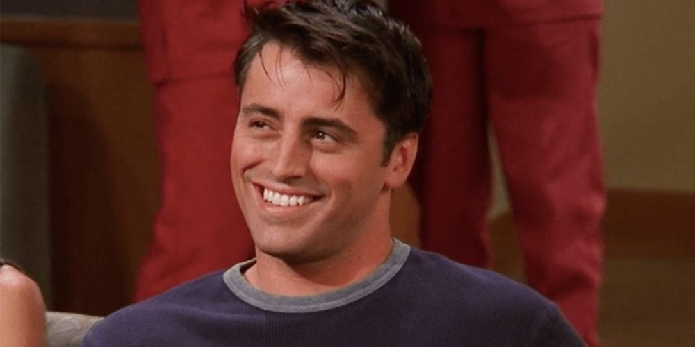Joey Tribbiani looking up and grinning in Friends 
