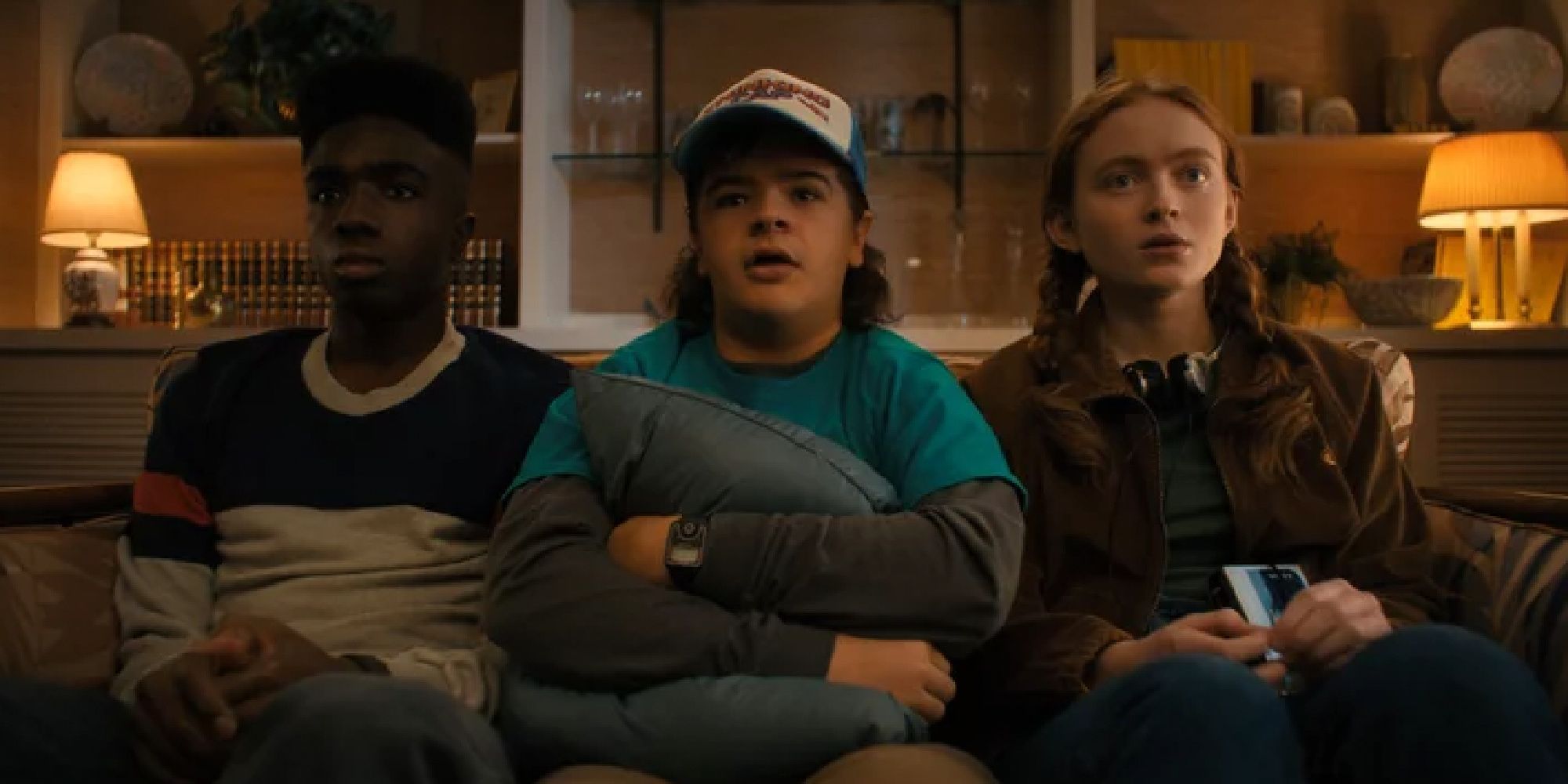 Lucas, Dustin, and Max on the couch on Stranger Things