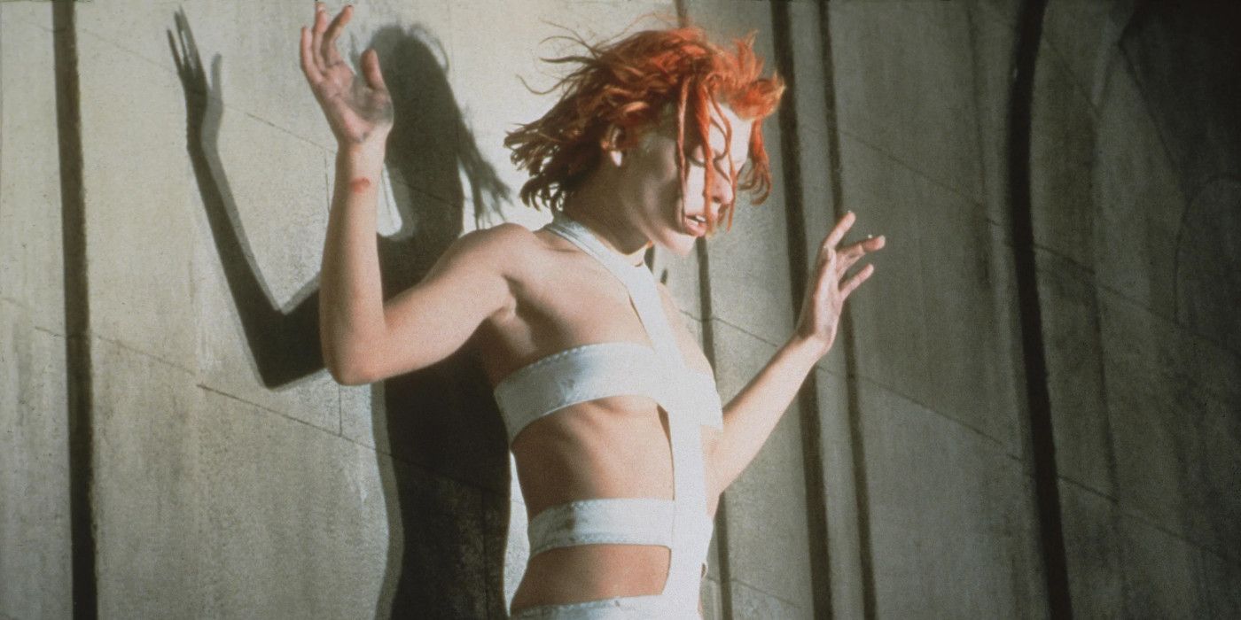 Milla Jovovich in The Fifth Element in her iconic bandage costume as Leeloo looking down with her hands up