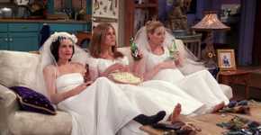 Monica Rachel and Phoebe sitting on the couch in wedding dresses and eating popcorn in Friends