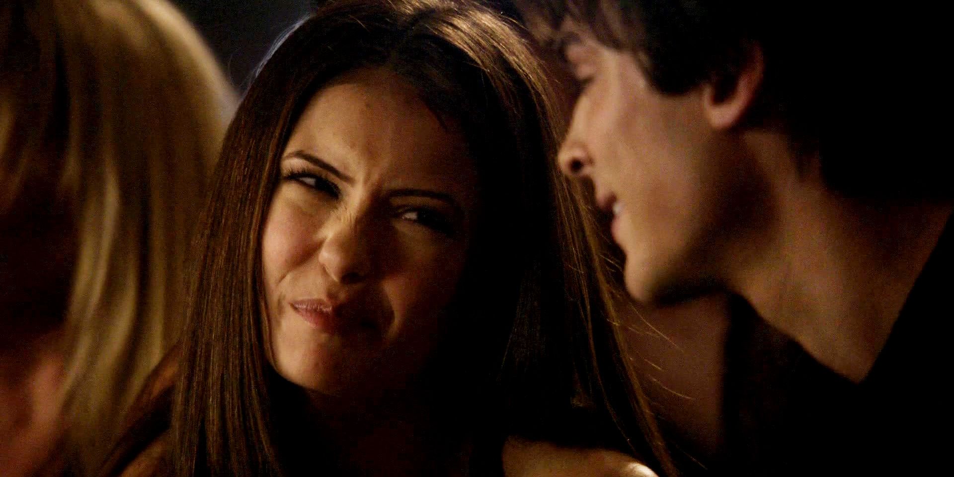 Elena at the bar making fun of Damon for being able to drink more than him in The Vampire Diaries.