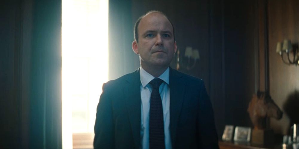 Bill stands at his desk in No Time to Die